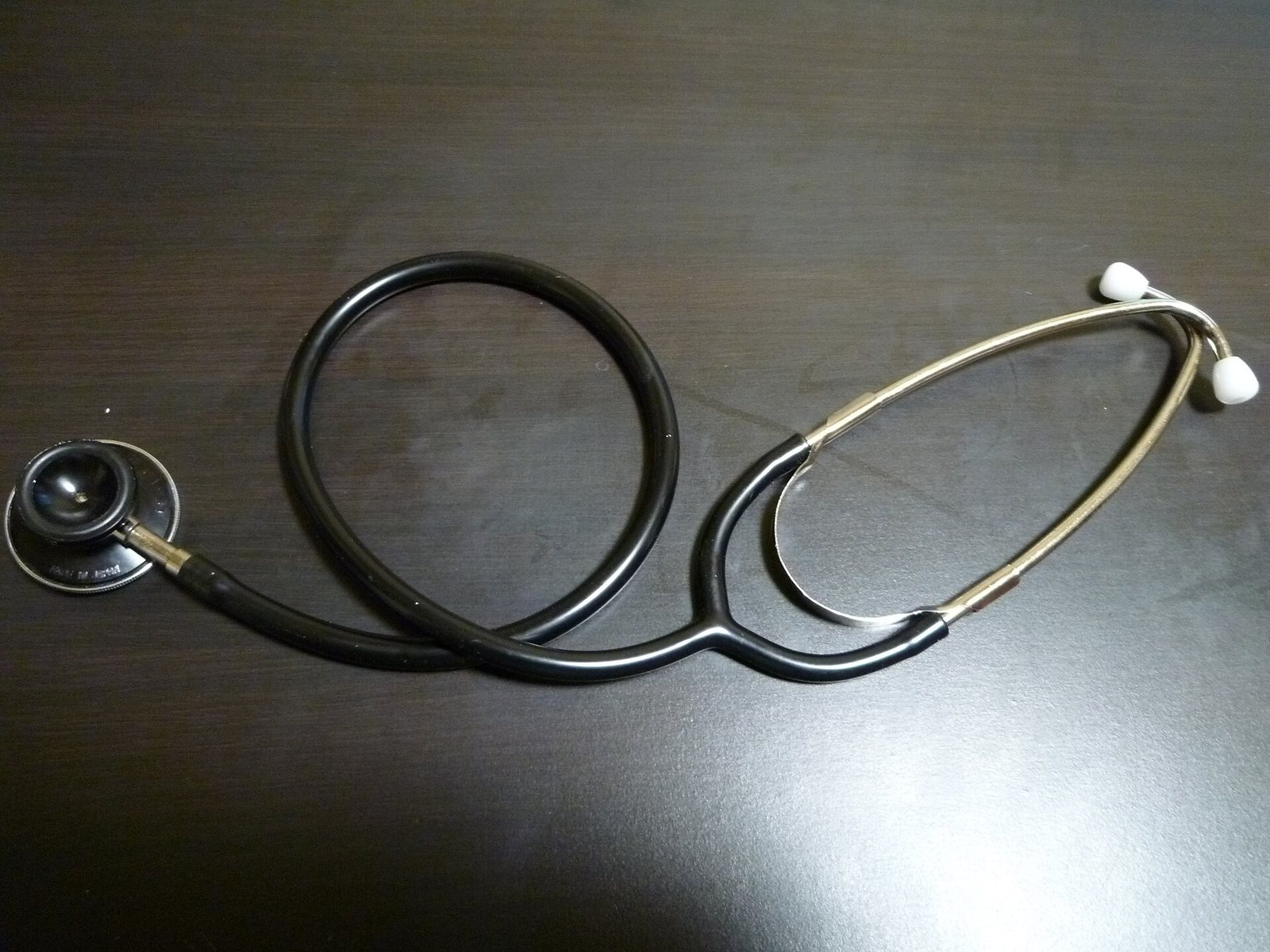 A stethoscope resting on a dark surface